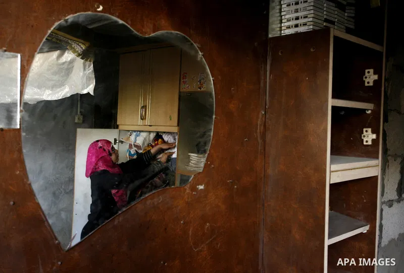 A Palestinian woman arranges her belongings inside her bad-built home in Khan Younis refugee camp in southern Gaza Strip, 21 February 2012. The United Nations Relief and Works Agency (UNRWA) stated that the Israeli block...