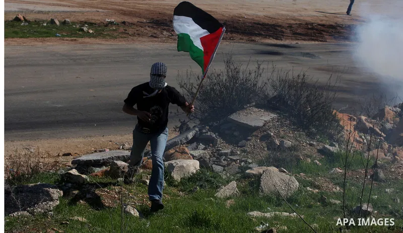 A Palestinian protester throws a stone towards Israeli troops during clashes outside Ofer prison near the West Bank city of Ramallah February 21, 2012. The clashes broke out after a protest in support of Islamic Jihad me...
