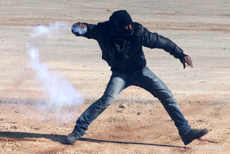 A Palestinian protester throws a stone towards Israeli troops during clashes outside Ofer prison near the West Bank city of Ramallah February 21, 2012. The clashes broke out after a protest in support of Islamic Jihad me...