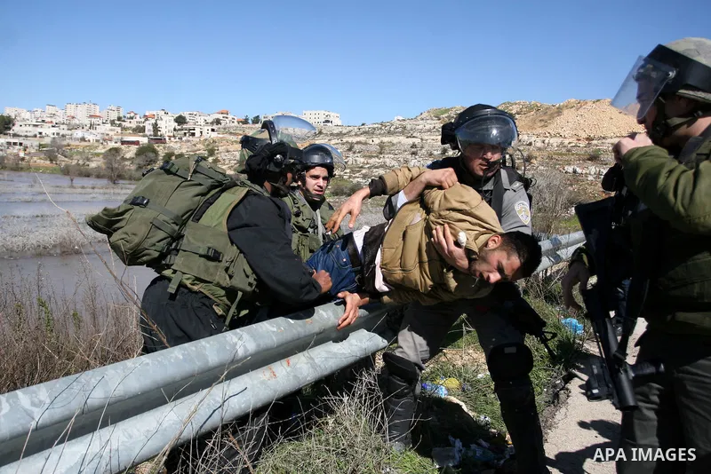 Israeli soldiers detain a Palestinian protester at the entrance of Ofer Prison near Ramallah in the occupied West Bank during a demonstration in support of a fellow prisoner who has ended on February 21, 2012 a 66-day hu...