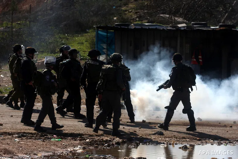 A Palestinian protester throws a stone towards Israeli troops during clashes outside Ofer prison near the West Bank city of Ramallah February 21, 2012. The clashes broke out after a protest in support of Islamic Jihad me...
