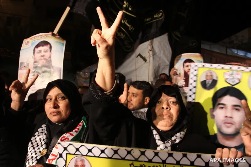 Palestinians celebrate the Israeli court decision to release Islamic Jihad member Khader Adnan from prison, in front of the Red Cross headquarters in Gaza city, Tuesday, Feb. 21, 2012. Adnan agreed to end his 66-day hung...