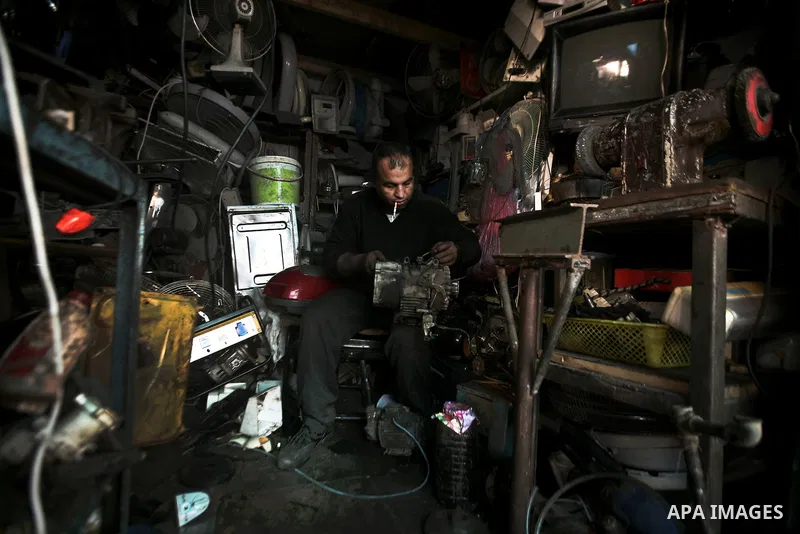 A Palestinian man repairs electrical devices in one of the old streets in the Jabaliya refugee camp northern Gaza Strip 22 February 2012. The United Nations Relief and Works Agency (UNRWA) states that the Israeli blockad...