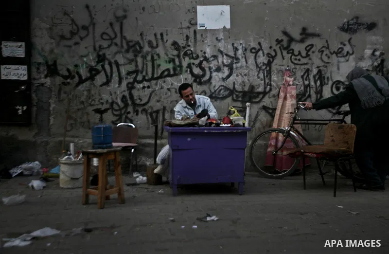 A Palestinian man repairs shoes in one of the old streets in the Jabaliya refugee camp northern Gaza Strip 22 February 2012. The United Nations Relief and Works Agency (UNRWA) states that the Israeli blockade on Gaza has...
