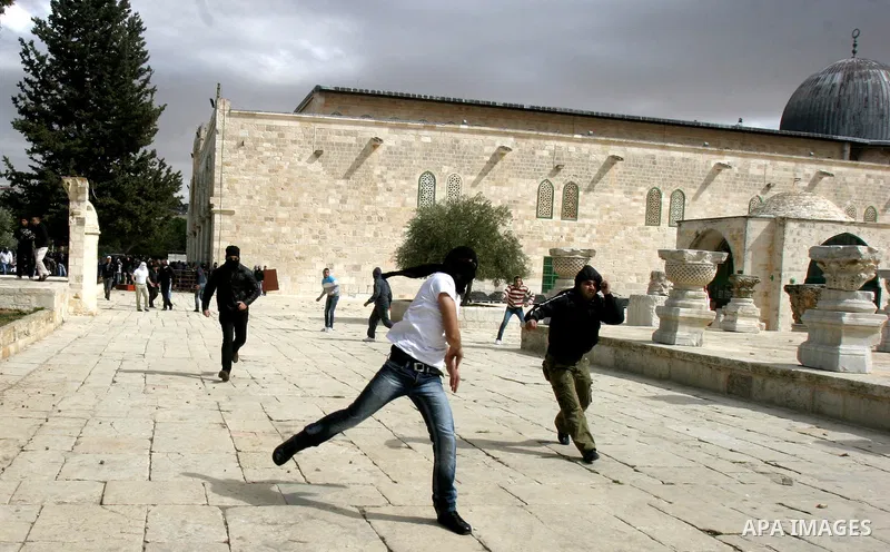 A Palestinian protester hurls stones during clashes with Israeli policemen on the compound known to Muslims as the Noble Sanctuary and to Jews as the Temple Mount in Jerusalem's Old City February 24, 2012. Israeli police...