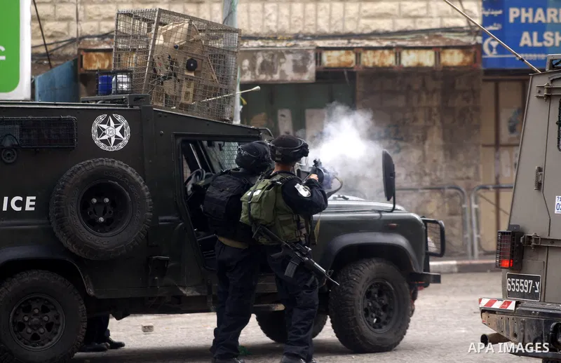 An Israeli policeman fires a tear gas canister during clashes with Palestinian protesters at a demonstration against the closure of Shuhada street to Palestinians, in the West Bank city of Hebron February 24, 2012. Some...