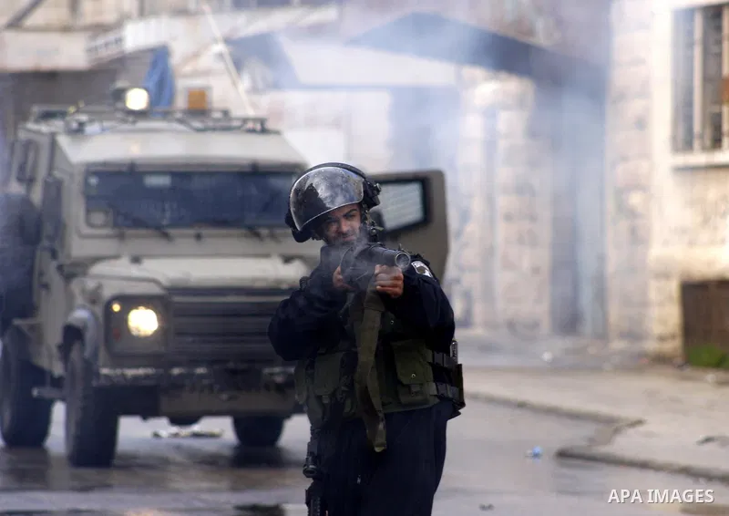An Israeli policeman fires a tear gas canister during clashes with Palestinian protesters at a demonstration against the closure of Shuhada street to Palestinians, in the West Bank city of Hebron February 24, 2012. Some...