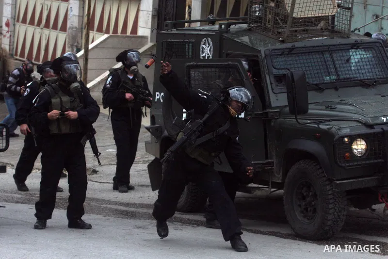 Israeli policemen fire tear gas grenades during a demonstration by Palestinians and peace activists demanding the reopening of a key street in the West Bank city of Hebron, 24 February 2012. Hundreds of Palestinians prot...