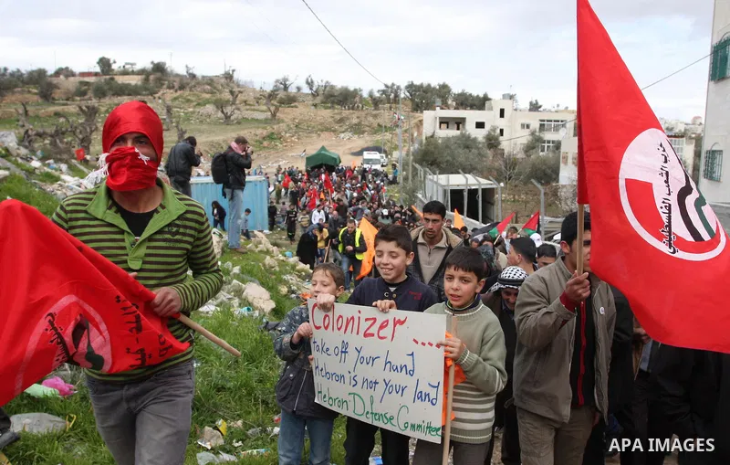 Palestinian demonstrators, joined by Israeli and foreign peace activists, shout slogans during a demonstration demanding the reopening of a key street in the West Bank city of Hebron on February 24, 2012. Hundreds of Pal...