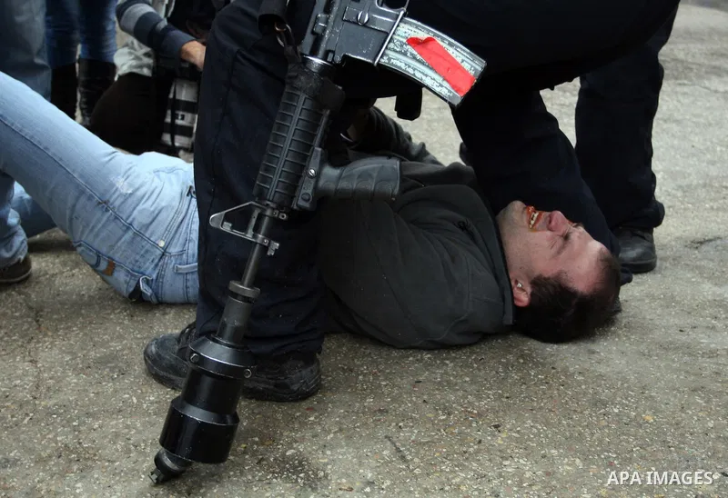 Israeli troops arrest a protester during a demonstration by Palestinians and peace activists demanding the reopening of a key street in the West Bank city of Hebron on February 24, 2012. Hundreds of Palestinians proteste...