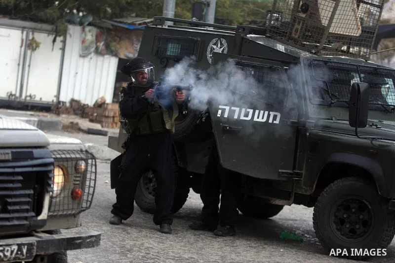 Israeli policemen fire tear gas grenades during a demonstration by Palestinians and peace activists demanding the reopening of a key street in the West Bank city of Hebron, 24 February 2012. Hundreds of Palestinians prot...