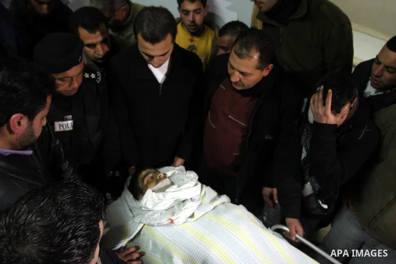Palestinians relatives mourn over the body of Talat Ramya "25", killed by Israeli military, during clashes following a weekly demonstration at the West bank refugee camp of Qalandia, near Ramallah, on Feb. 24. 2012. Phot...