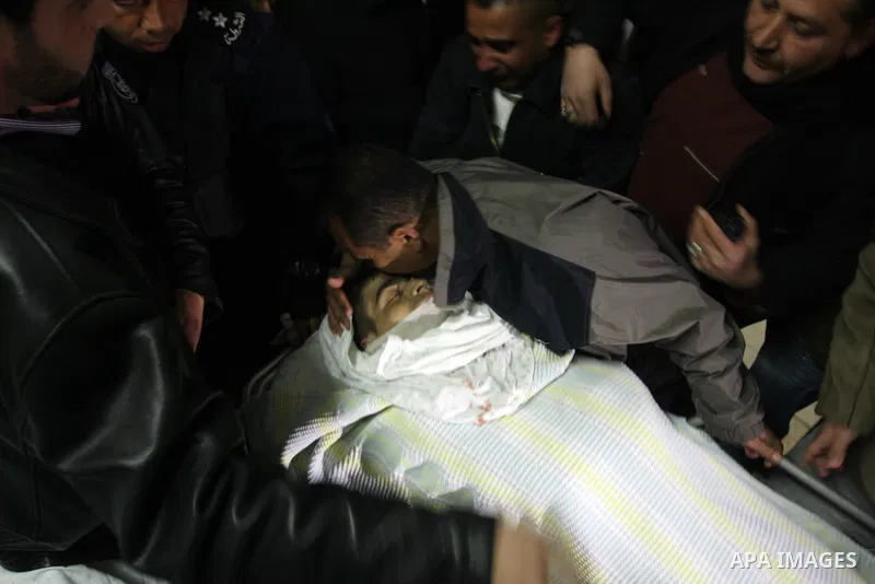 Palestinians relatives mourn over the body of Talat Ramya "25", killed by Israeli military, during clashes following a weekly demonstration at the West bank refugee camp of Qalandia, near Ramallah, on Feb. 24. 2012. Phot...