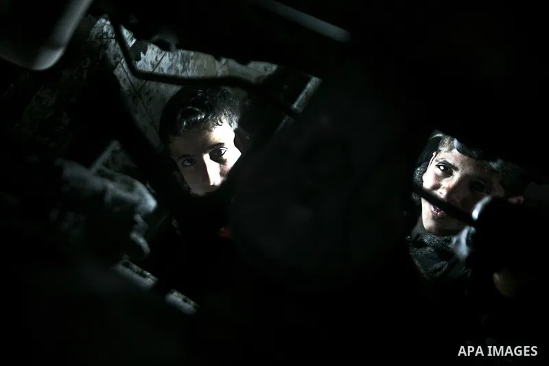 Palestinian children work repairing a car tyre in the town of Beit Lahyia in northern Gaza on 23 February 2012. Reports state that child labor is widespread in the Gaza Strip because of the high rate of poverty and unemp...