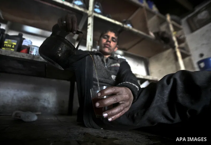 Palestinian children having their tea in a car repair workshop in the town of Beit Lahyia in northern Gaza on 23 February 2012. Reports state that child labor is widespread in the Gaza Strip because of the high rate of p...