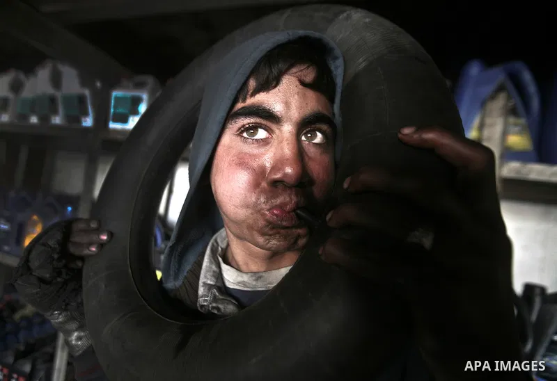 Palestinian 12 yearold Tarek, inflates an inner tube while repairing a customers car in the town of Beit Lahyia in northern Gaza on 23 February 2012. Reports state that child labor is widespread in the Gaza Strip because...