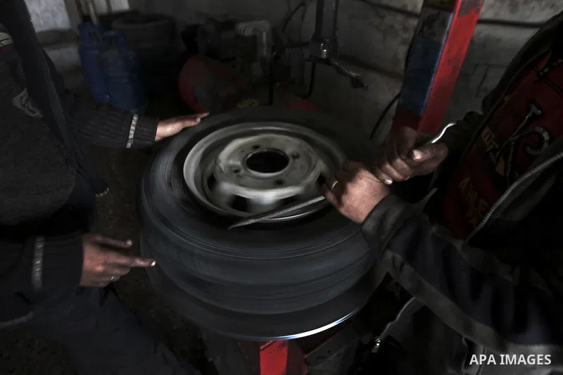Palestinian children work repairing a car tyre in the town of Beit Lahyia in northern Gaza on 23 February 2012. Reports state that child labor is widespread in the Gaza Strip because of the high rate of poverty and unemp...