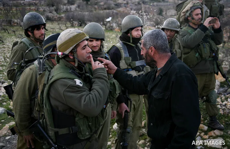 Israeli soldiers face Palestinians protesters who gathered for a protest against a Jewish settlement near the West Bank village of Beit Omar, close to the city of Hebron and the settlement of Karmei Tzur, on 25 February...