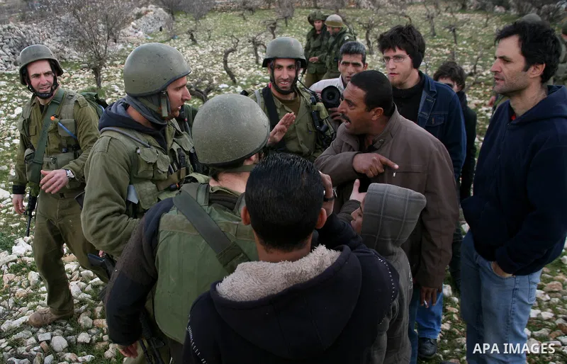 Israeli soldiers face Palestinians protesters who gathered for a protest against a Jewish settlement near the West Bank village of Beit Omar, close to the city of Hebron and the settlement of Karmei Tzur, on 25 February...