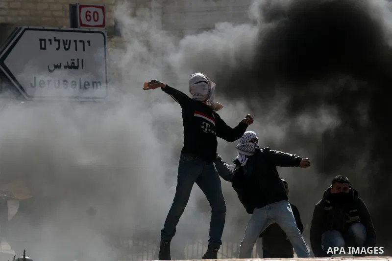 Palestinians stone thrower pelts a stone during clashes with Israeli soldiers in the West Bank neighbourhood of Al-Ram, adjacent to Israeli-annexed east Jerusalem, on February 25, 2012. At least nine Palestinians were in...