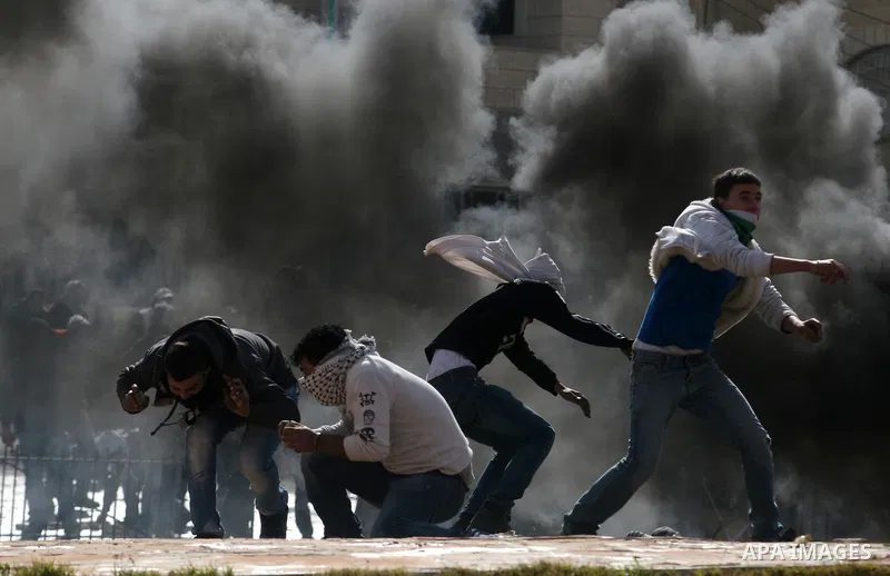 Palestinians stone thrower pelts a stone during clashes with Israeli soldiers in the West Bank neighbourhood of Al-Ram, adjacent to Israeli-annexed east Jerusalem, on February 25, 2012. At least nine Palestinians were in...
