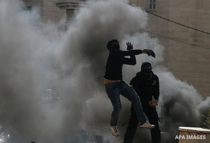 Palestinians stone thrower pelts a stone during clashes with Israeli soldiers in the West Bank neighbourhood of Al-Ram, adjacent to Israeli-annexed east Jerusalem, on February 25, 2012. At least nine Palestinians were in...