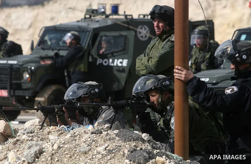 Israeli soldiers take position during clashes with Palestinian stone throwers in the West Bank neighbourhood of Al-Ram, adjacent to Israeli-annexed east Jerusalem, on February 25, 2012. At least nine Palestinians were in...