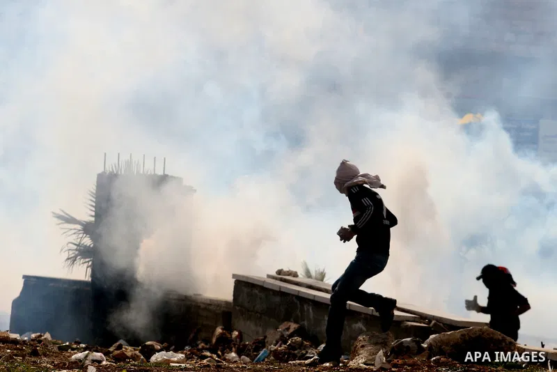 Palestinians stone thrower pelts a stone during clashes with Israeli soldiers in the West Bank neighbourhood of Al-Ram, adjacent to Israeli-annexed east Jerusalem, on February 25, 2012. At least nine Palestinians were in...