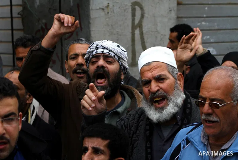 Palestinians take part in a protest in front of the UNRWA headquarters, against reducing the services provided to Palestine refugees in Gaza city, on Feb. 26, 2012. Photo by Ashraf Amra