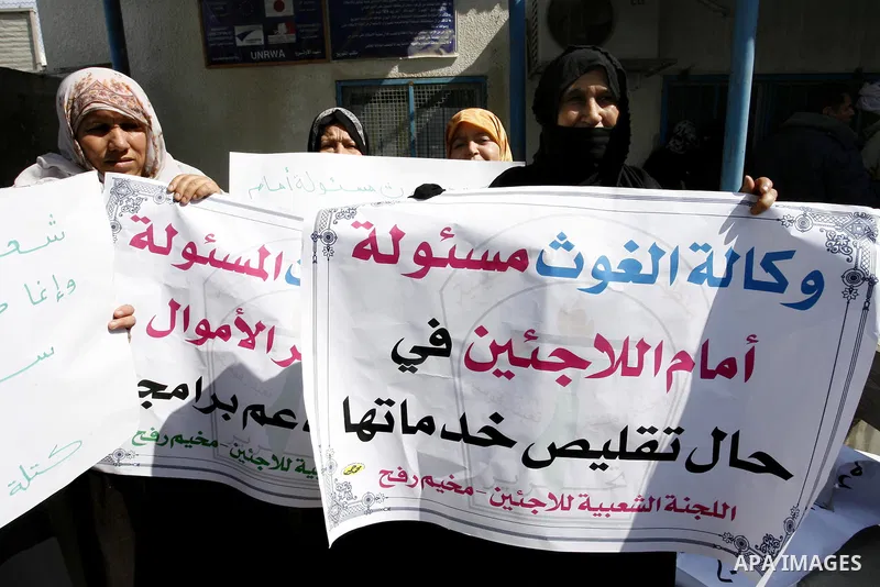 Palestinians take part during a protest against the suspension of aid provided to them from the Agency Relief and Works Agency (UNRWA) during a protest in front of one of the centers of the distribution of aid to UNRWA i...