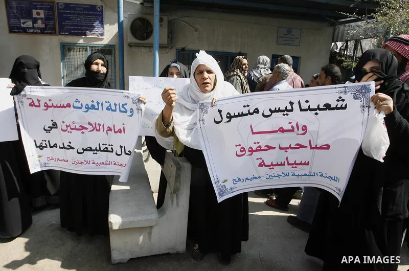 Palestinians take part during a protest against the suspension of aid provided to them from the Agency Relief and Works Agency (UNRWA) during a protest in front of one of the centers of the distribution of aid to UNRWA i...