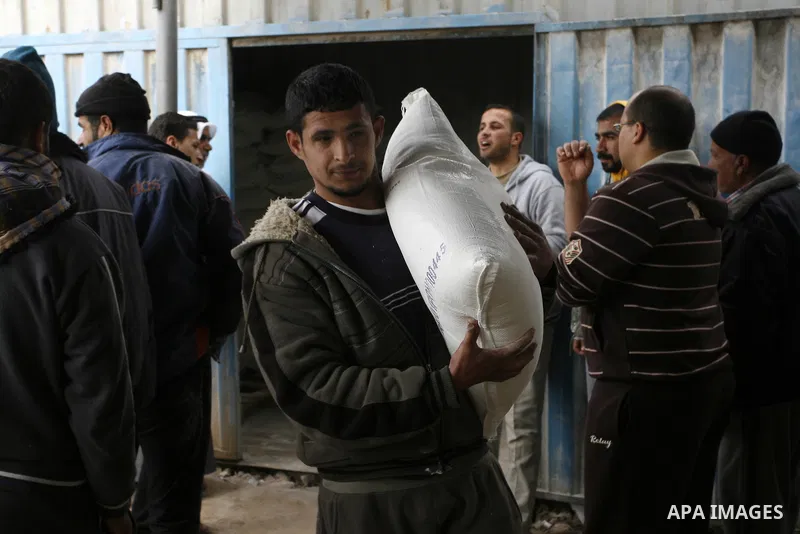 Palestinians receive their monthly food aid at a UN distribution center in the Rafah refugee camp, southern Gaza Strip on February 26, 2012. Photo by Abed Rahim Khatib