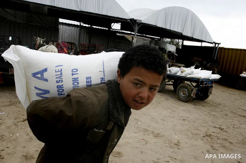 Palestinians receive their monthly food aid at a UN distribution center in the Rafah refugee camp, southern Gaza Strip on February 26, 2012. Photo by Abed Rahim Khatib