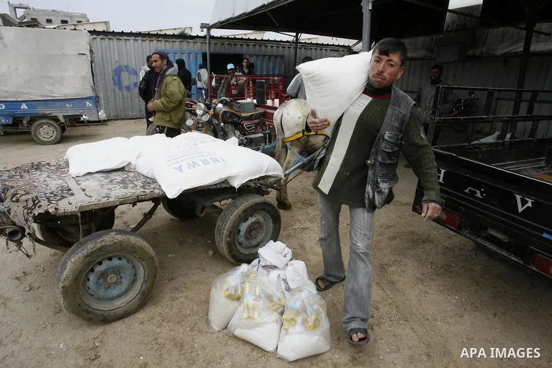 Palestinians receive their monthly food aid at a UN distribution center in the Rafah refugee camp, southern Gaza Strip on February 26, 2012. Photo by Abed Rahim Khatib
