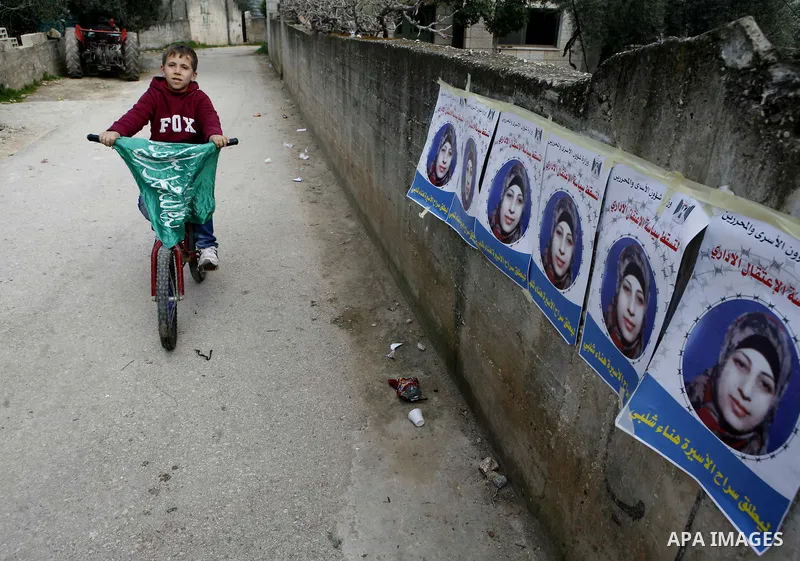 Relatives of Palestinian detainee, Hana Shalabi, stick up placards depicting Shalabi, in the West Bank village of Birqin, near Jenin February 27, 2012. Shalabi, released by Israel in a prisoner swap last year but re-arre...