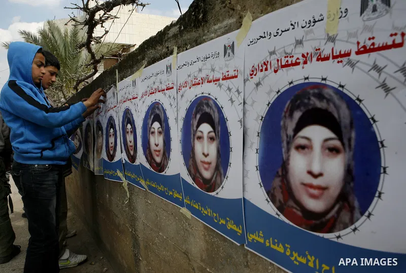 Relatives of Palestinian detainee, Hana Shalabi, stick up placards depicting Shalabi, in the West Bank village of Birqin, near Jenin February 27, 2012. Shalabi, released by Israel in a prisoner swap last year but re-arre...