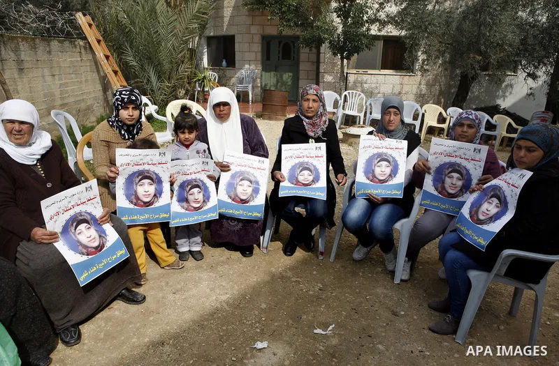 Relatives of Palestinian detainee, Hana Shalabi, holds placards depicting Shalabi, in the West Bank village of Birqin, near Jenin February 27, 2012. Shalabi, released by Israel in a prisoner swap last year but re-arreste...