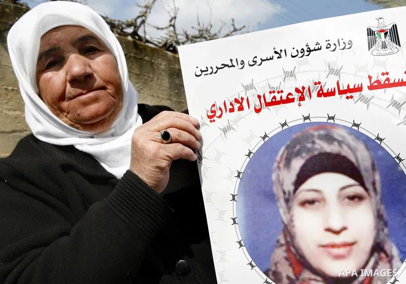 Badeeah Shalabi holds a placard depicting her daughter, Palestinian detainee Hana Shalabi, in the West Bank village of Birqin, near Jenin February 27, 2012. Hana Shalabi, released by Israel in a prisoner swap last year b...