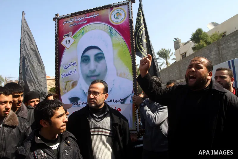 Palestinian Protestors hold a picture of Palestinian prisoner Hana'a Shalabi during a protest outside the United Nations building in Gaza City on February 28, 2012. Shalabi, released by Israel in a prisoner swap last yea...
