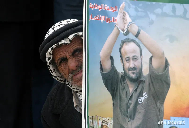 Palestinians hold a picture for Hana Al-Shalabi, a Palestinian prisoner on hunger strike jailed in Israel, as they protest against Israel's policy of administrative detention, in the West Bank city of Ramallah , Monday,...