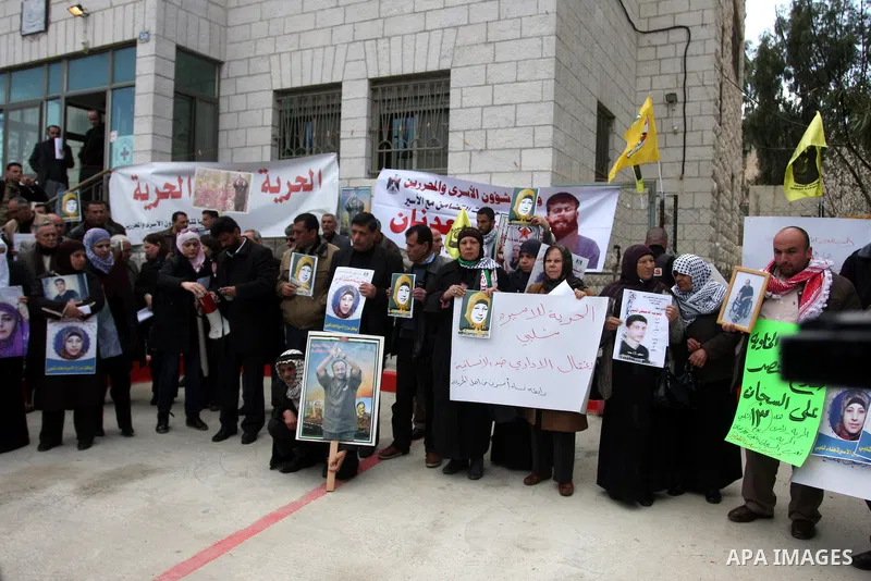 Palestinians hold a picture for Hana Al-Shalabi, a Palestinian prisoner on hunger strike jailed in Israel, as they protest against Israel's policy of administrative detention, in the West Bank city of Ramallah , Monday,...