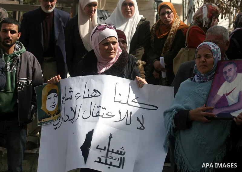 Palestinians hold a picture for Hana Al-Shalabi, a Palestinian prisoner on hunger strike jailed in Israel, as they protest against Israel's policy of administrative detention, in the West Bank city of Ramallah , Monday,...