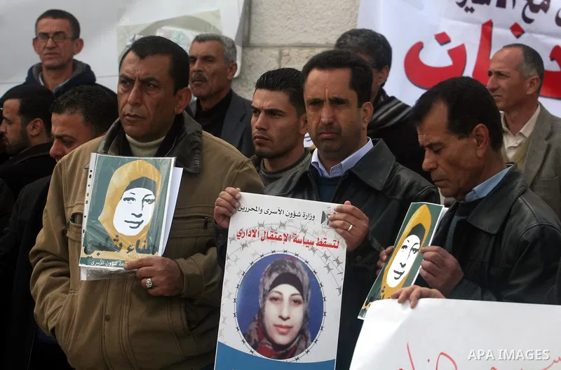 Palestinians hold a picture for Hana Al-Shalabi, a Palestinian prisoner on hunger strike jailed in Israel, as they protest against Israel's policy of administrative detention, in the West Bank city of Ramallah , Monday,...