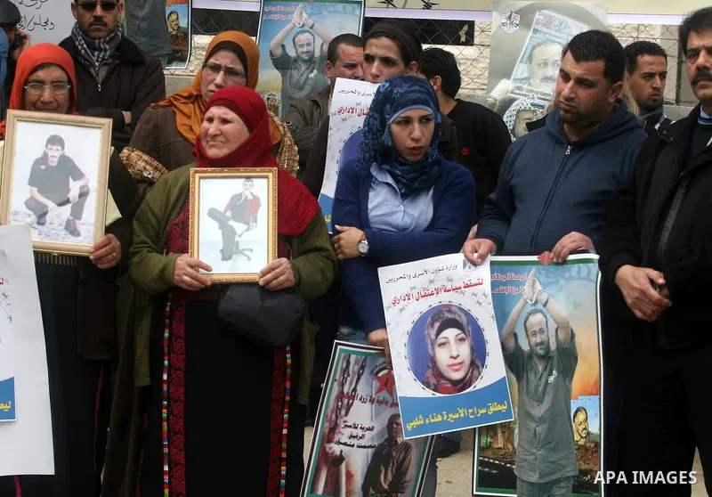 Palestinians hold a picture for Hana Al-Shalabi, a Palestinian prisoner on hunger strike jailed in Israel, as they protest against Israel's policy of administrative detention, in the West Bank city of Ramallah , Monday,...