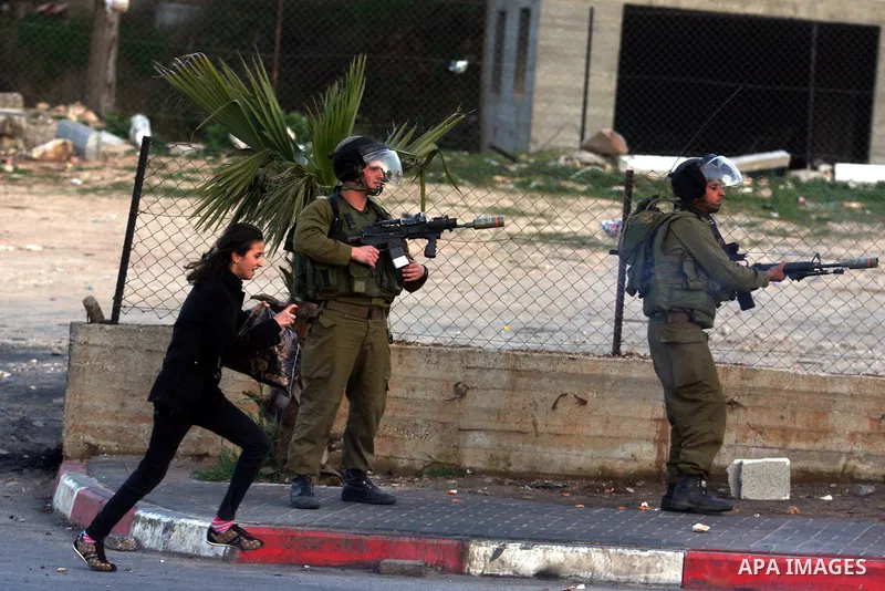 An Israeli soldier fires tear gas during clashes with stone-throwing Palestinians in the West Bank district of al-Ram, bordering Israel and annexed East Jerusalem, on February 28, 2012. Photo by Issam Rimawi
