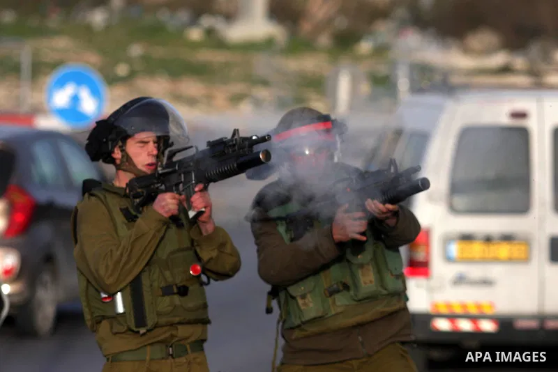 An Israeli soldier fires tear gas during clashes with stone-throwing Palestinians in the West Bank district of al-Ram, bordering Israel and annexed East Jerusalem, on February 28, 2012. Photo by Issam Rimawi