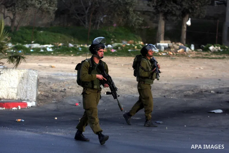 An Israeli soldier fires tear gas during clashes with stone-throwing Palestinians in the West Bank district of al-Ram, bordering Israel and annexed East Jerusalem, on February 28, 2012. Photo by Issam Rimawi