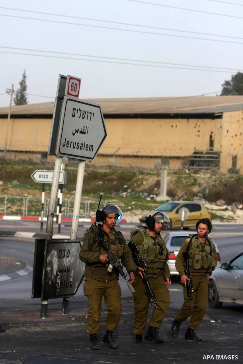 An Israeli soldier fires tear gas during clashes with stone-throwing Palestinians in the West Bank district of al-Ram, bordering Israel and annexed East Jerusalem, on February 28, 2012. Photo by Issam Rimawi