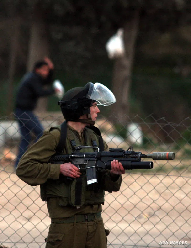An Israeli soldier fires tear gas during clashes with stone-throwing Palestinians in the West Bank district of al-Ram, bordering Israel and annexed East Jerusalem, on February 28, 2012. Photo by Issam Rimawi