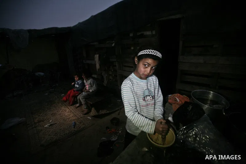 A Palestinian girl cooks on at her house inbetween makeshift tents in one of the most poor regions in Al-Nusirat neighborhood, central Gaza Strip on 28 February 2012. The United Nations Relief and Works Agency for Palest...